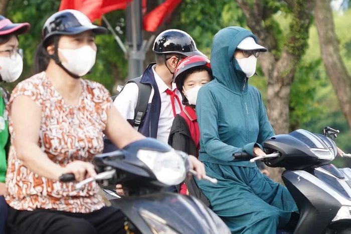 Trẻ nhỏ được cha mẹ mặc thêm áo ấm, che chắn khi ra đường vào sáng sớm.