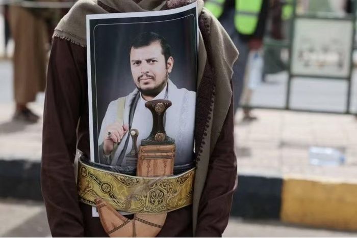 Một người ủng hộ Houthi cài ảnh chân dung lãnh đạo Abdul Malik al-Houthi ở thắt lưng khi tham gia cuộc tuần hành phản đối liên minh của Ả-rập Xê-út ở Sanaa hồi tháng 7. (Ảnh: Reuters)