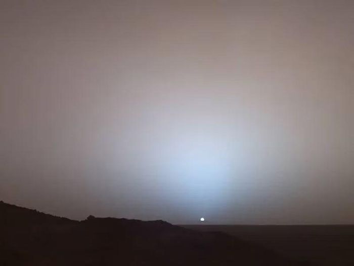 Ngày 19/5/2005, robot thám hiểm Sao Hỏa Spirit của NASA ghi lại khung cảnh tuyệt đẹp này khi Mặt Trời lặn xuống dưới vành miệng hố va chạm Gusev trên Sao Hỏa. Hình ảnh ghép từ camera toàn cảnh này được chụp vào khoảng 6 giờ 7 phút chiều, trong ngày thứ 489 (hay còn gọi là “sol”) của robot Spirit trên Sao Hỏa. Ảnh: NASA.