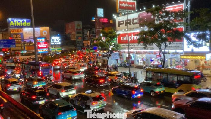 Tại ngã tư Hàng Xanh, đến 19h30 tối, mưa vẫn nặng hạt, lượng phương tiện qua lại đông, nhiều thời điểm ùn ứ. Cả nghìn người dầm mưa chờ cán bộ, chiến sĩ Đội CSGT Hàng Xanh điều tiết, phân luồng.