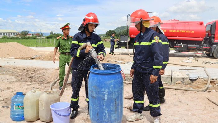 Các cán bộ, chiến sĩ dùng vòi dẫn nước vào can, thùng phuy, bể chứa của người dân đã chuẩn bị sẵn.