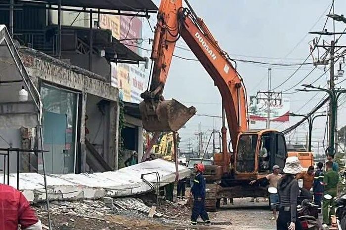 Lực lượng cứu hộ dùng xe cẩu nâng khối bê tông để đưa nạn nhân ra ngoài. Ảnh: A.X