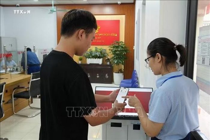 Cán bộ Trung tâm phục vụ hành chính công xã Yên Mỹ hướng dẫn người dân thực hiện thủ tục hành chính. Ảnh: Mạnh Khánh/TTXVN