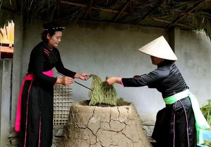 Tỉ mỉ sấy lúa nếp theo phương pháp thủ công trên bếp lò để tạo nên những mẻ cốm thơm dẻo.