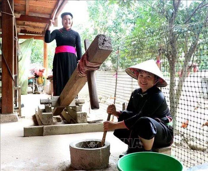 Bên cối đá, người thoăn thoắt giã, người khéo léo vén cốm, cùng tạo nên những mẻ cốm xanh thơm dẻo.