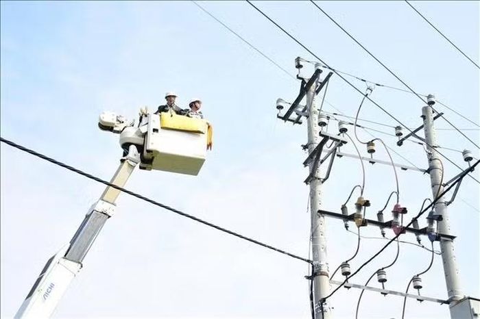 Công nhân EVNHANOI kiểm tra đường dây trên cao bằng hệ thống xe nâng chuyên dụng. Ảnh: Quốc Lũy/TTXVN