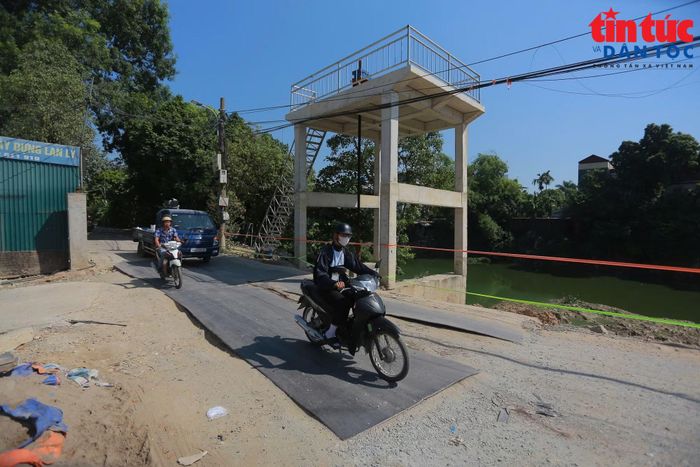 Người dân phải đi qua các tấm thép được đặt tạm để khắc phục.