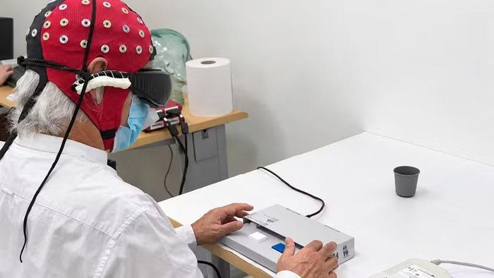 Bệnh nhân viêm võng mạc sắc tố đeo kính chuyên dụng trong thử nghiệm quang di truyền học, kết hợp theo dõi hoạt động não. Ảnh: Nature Medicine.