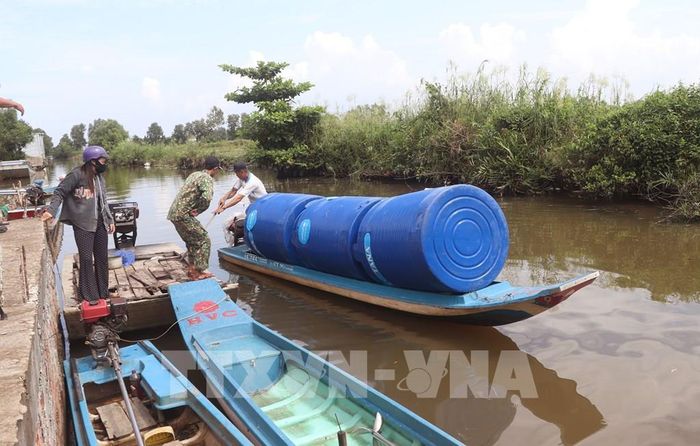 Người dân xã Biển Bạch vận chuyển dụng cụ chứa nước về nhà. Ảnh: Tuấn Phi - TTXVN