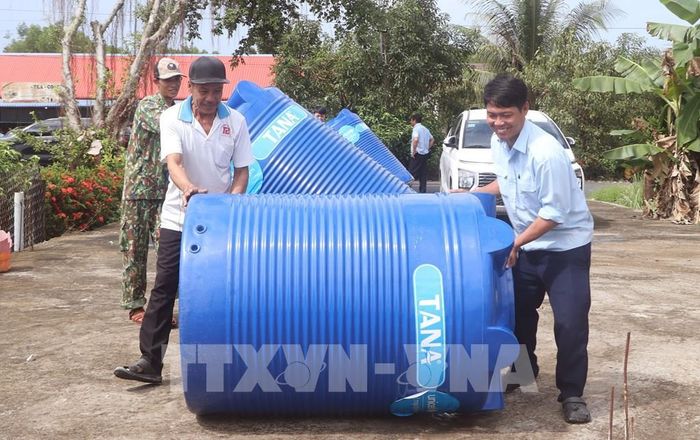 Người dân xã Biển Bạch vận chuyển dụng cụ chứa nước về nhà. Ảnh: Tuấn Phi - TTXVN