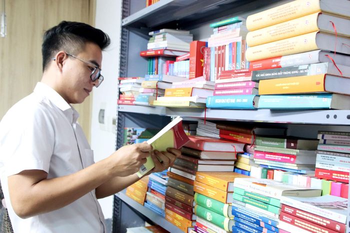 Nguyễn Văn Hiệu sắp xếp, kiểm tra tư liệu tại phòng làm việc. Ảnh: TRỌNG HUY