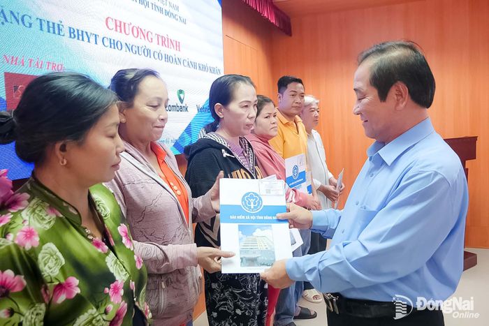 Giám đốc BHXH Đồng Nai Phạm Minh Thành trao tặng thẻ BHYT cho người dân có hoàn cảnh khó khăn trên địa bàn thành phố. Ảnh: Hạnh Dung