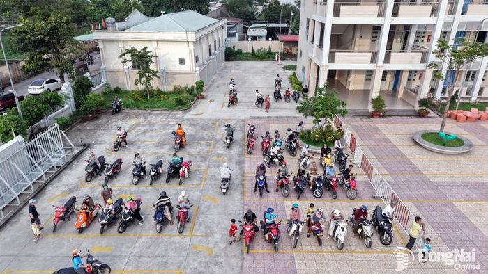 Phụ huynh xếp hàng ngay ngắn trong các ô vạch sơn màu vàng để sẵn sàng đón học sinh sau giờ tan học. Ảnh: Công Nghĩa
