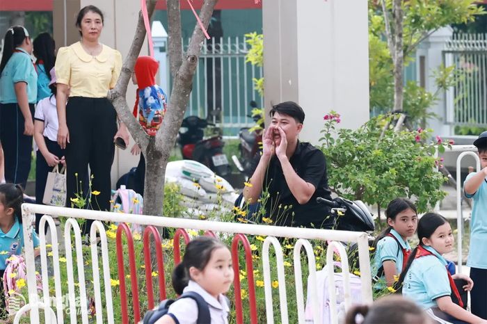 Một phụ huynh gọi con từ xa, giúp con biết vị trí khu vực đậu xe. Ảnh: Công Nghĩa