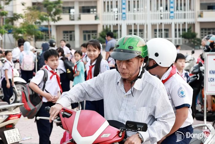 Phụ huynh và học sinh đều chấp hành đội mũ bảo hiểm khi đi xe máy. Ảnh: Công Nghĩa