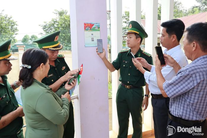 Cán bộ, chiến sĩ Đồn biên phòng Thanh Hòa hướng dẫn người dân thôn Đoàn Kết, xã Thiện Hưng cài đặt hòm thư điện tử tố giác tội phạm. Ảnh: Nguyệt Hà