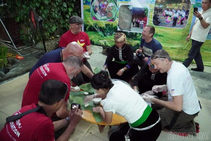 Du khách trải nghiệm gói bánh truyền thống cùng người dân địa phương. 