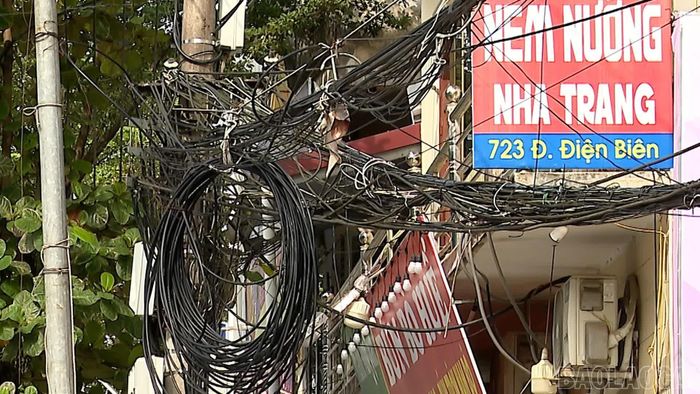 Dây điện, cáp viễn thông cũ, mới cùng tồn tại, chằng chịt trước nhà dân.