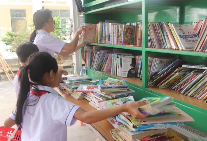 Học sinh lựa chọn sách tại xe thư viện lưu động để đọc