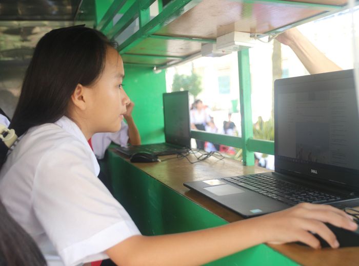 Học sinh sử dụng máy tính tìm kiếm tư liệu tại xe thư viện lưu động Thư viện tỉnh