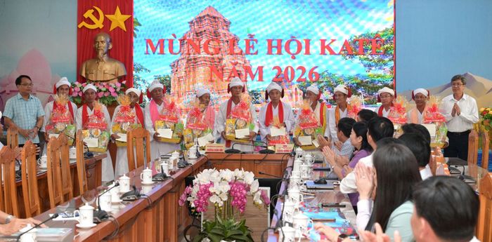 Đồng chí Đặng Hồng Sỹ (ngoài cùng bên trái) và đồng chí Nguyễn Minh (ngoài cùng bên phải) tặng quà cho các vị chức sắc, sư cả, người có uy tín trong cộng đồng Chăm Bàlamôn dịp Tết Katê