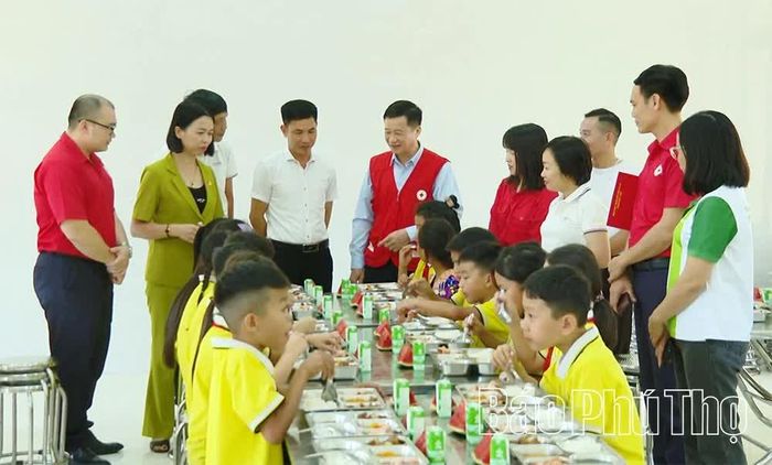 Lãnh đạo Hội Chữ thập đỏ tỉnh và Công ty TNHH Care For Việt Nam tham dự bữa ăn của học sinh Trường Phổ thông dân tộc bán trú tiểu học Thu Cúc.