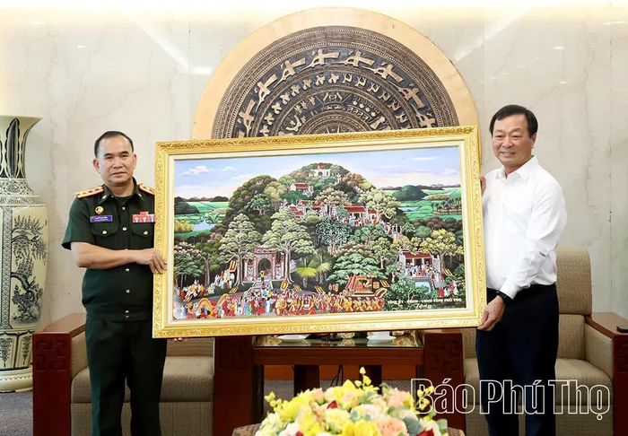 Đồng chí Bùi Văn Quang - Phó Bí thư Thường trực Tỉnh ủy trao quà lưu niệm tặng Đại tá Bùn-my Xay-pạ-sợt, Chỉ huy trưởng Bộ CHQS tỉnh Luông Nậm Thà và Đoàn công tác.