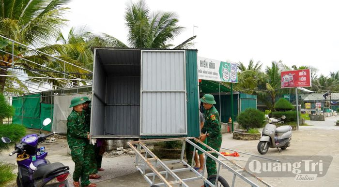 Các lực lượng chức năng hỗ trợ các hộ dân tháo dỡ công trình - Ảnh: H.Tr
