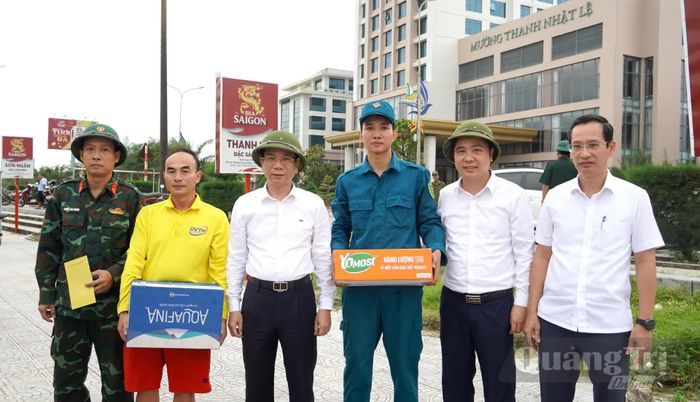 Đồng chí Phan Mạnh Hùng, Bí thư Đảng ủy phường Đồng Hới tặng quà động viên các lực lượng chức năng của phường đã hỗ trợ các hộ dân tháo dỡ công trình - Ảnh: H.Tr