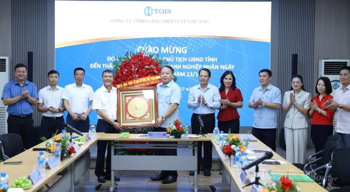 Chủ tịch UBND tỉnh Phan Huy Ngọc tặng quà và lẵng hoa chúc mừng Công ty Gang thép Tuyên Quang.