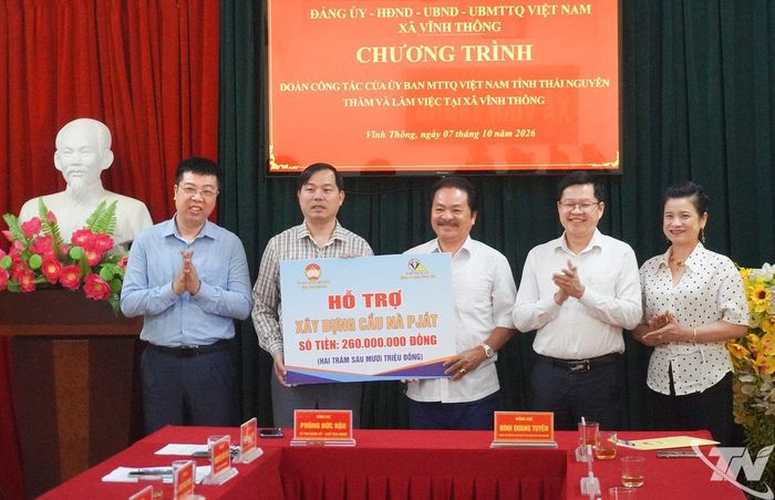 Đồng chí Đinh Quang Tuyên và đại diện đơn vị tài trợ trao hỗ trợ xây dựng cầu Nà Pját.