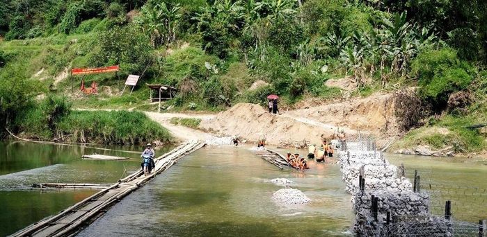 Cầu tạm đang được thi công giúp người dân lưu thông an toàn, thuận lợi. (Ảnh: Đỗ Hoạt).