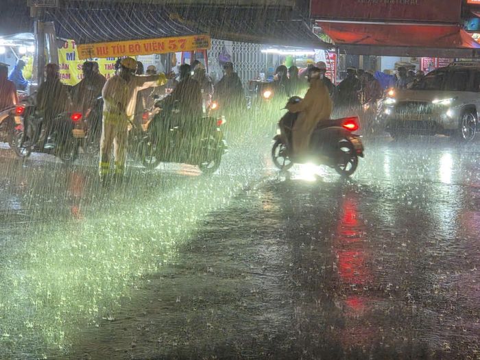 Lực lượng chức năng hỗ trợ phân luồng, điều tiết giao thông trong mưa lớn.