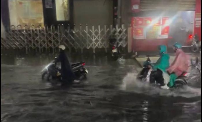 Người dân đội mưa, vượt qua các đoạn ngập để trở về nhà.