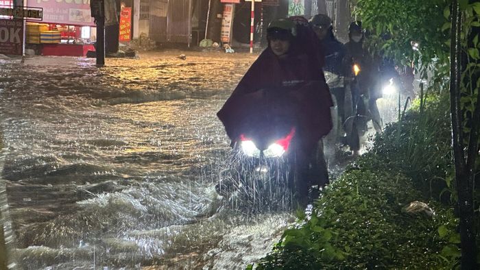 Người dân di chuyển khó khăn qua điểm ngập.