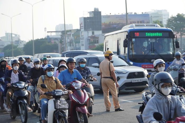 Cảnh sát giao thông phân luồng chuyển hướng dòng phương tiện tránh ùn ứ kéo dài.