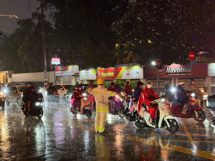 Cảnh sát giao thông điều tiết các phương tiện trong cơn mưa lớn tại giao lộ Điện Biên Phủ - Pasteur - Hai Bà Trưng, thuộc phường Xuân Hòa.