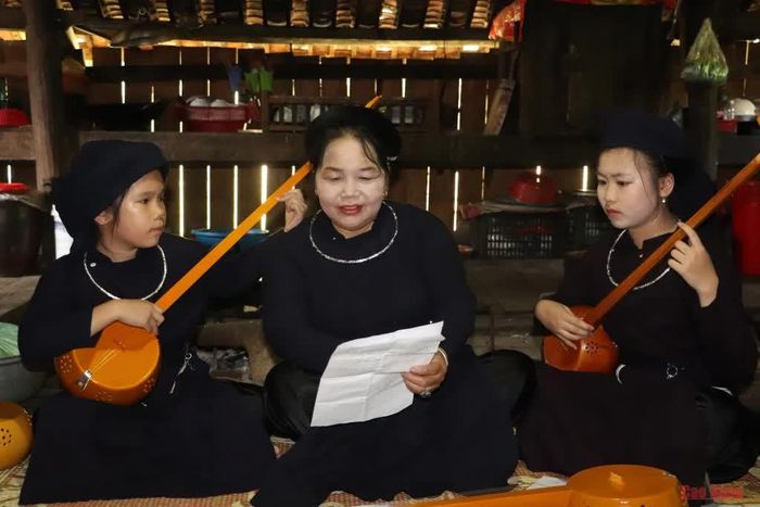 Chị Hà Thị Phòng hướng dẫn các cháu trong đội văn nghệ hát Then, đàn tính.