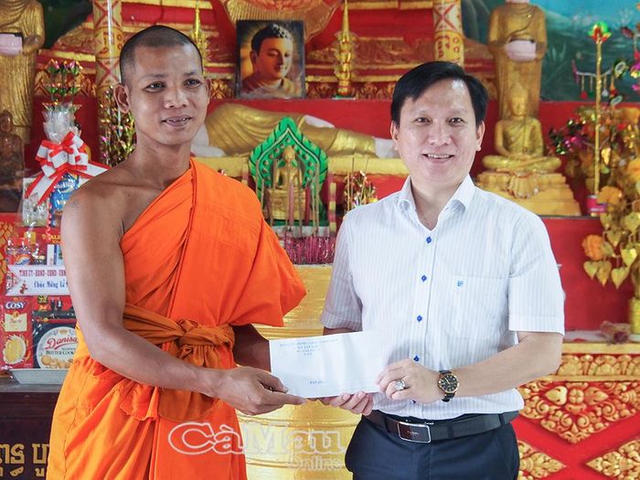Đồng chí Huỳnh Hảnh, Bí thư Đảng uỷ xã Tân Lộc, trao quà của Đảng uỷ, HĐND, UBND, Uỷ ban MTTQ Việt Nam xã Tân Lộc đến đại diện chùa Cao Dân.