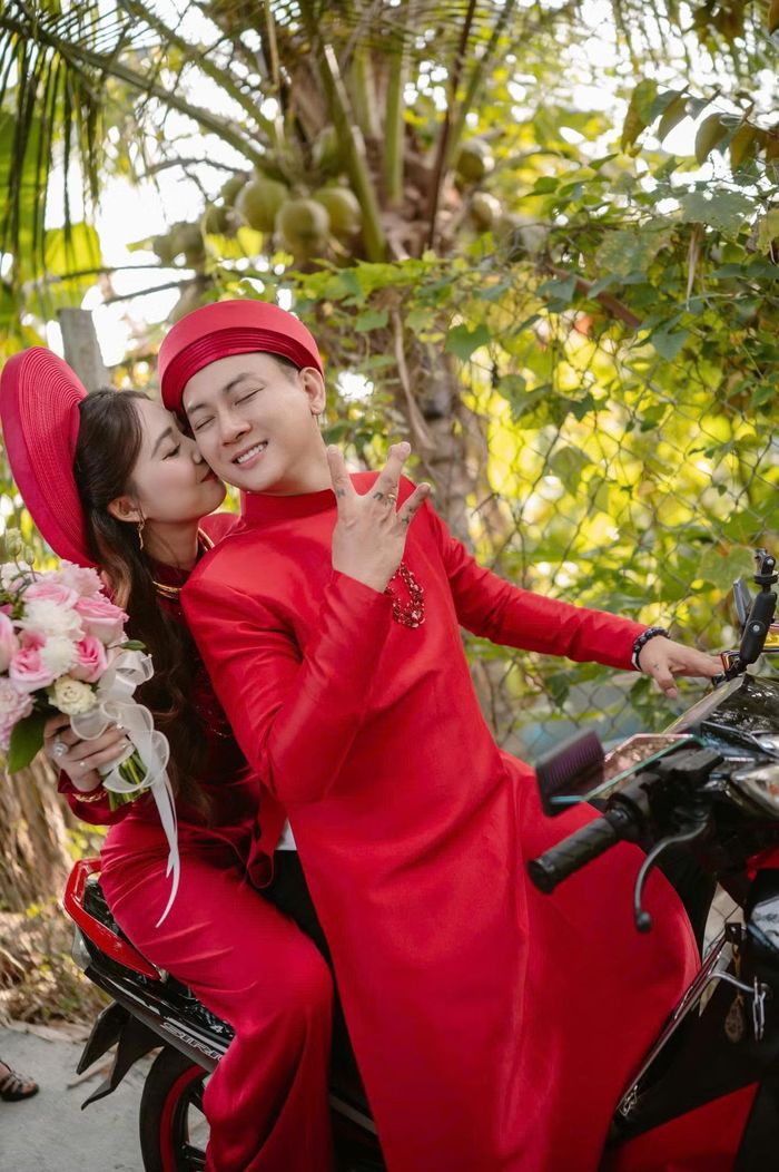 Hình ảnh nam ca sĩ mặc áo dài đỏ, chở vợ bằng xe máy trên đường quê trở thành một trong những khoảnh khắc được chú ý nhất. Đoàn rước dâu phía sau cũng chủ yếu di chuyển bằng xe máy, tạo khung cảnh khá đặc trưng của một đám cưới miền Tây.