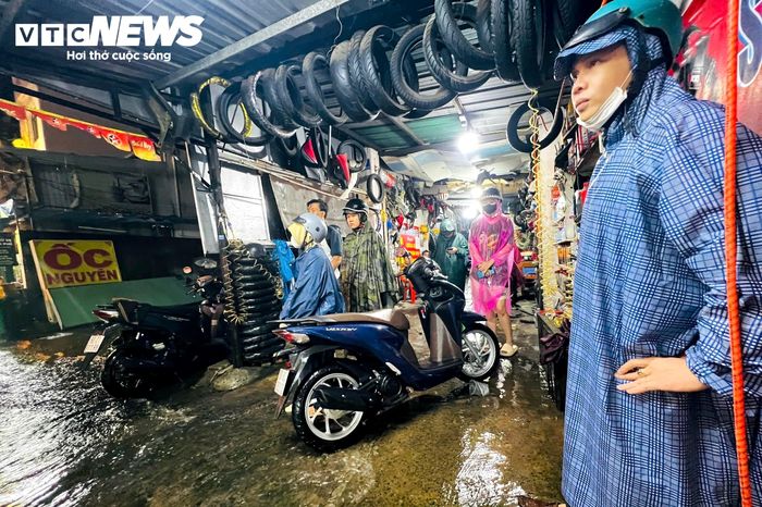 Tiệm sửa xe đông khách trong trận mưa lớn, nhiều người phải đưa xe vào sửa sau khi phương tiện chết máy vì ngập nước.