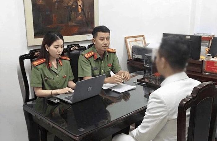 Cán bộ công an làm việc với người đăng tải thông tin sai sự thật trên mạng xã hội. Ảnh Công an thành phố Hà Nội