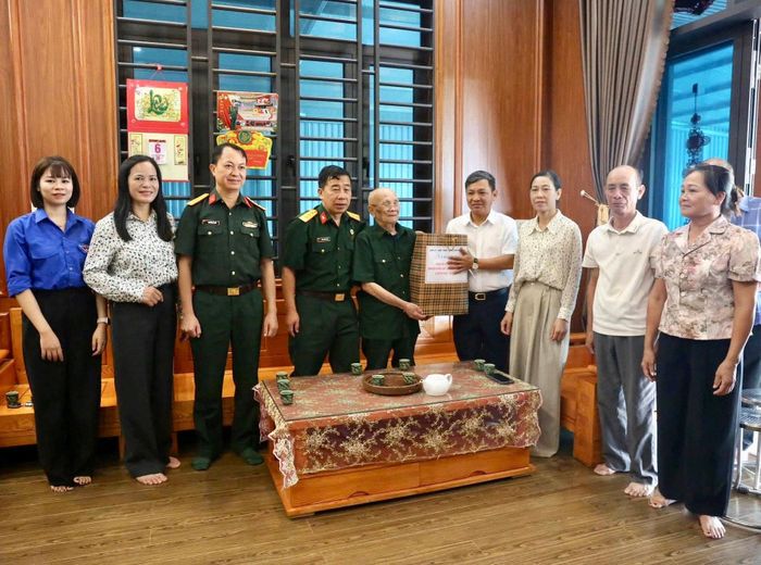 Phó Bí thư Đảng ủy, Chủ tịch UBND xã Sóc Sơn Phạm Quang Ngọc thăm, tặng quà cựu chiến binh. Ảnh: Tùng Nguyễn