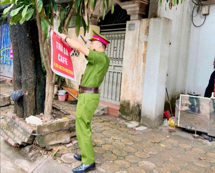 Công an phường Việt Hưng bóc dỡ quảng cáo sai quy định. Ảnh: PV