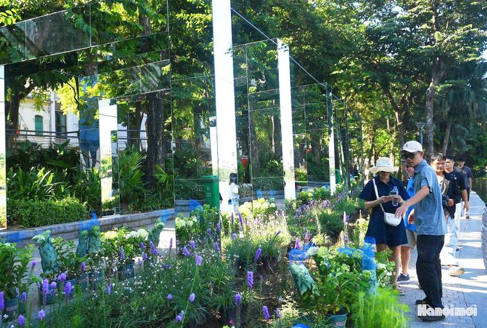 Trong dòng người tấp nập, những chiếc điện thoại liên tục được giơ lên. Người chỉnh dáng, người chọn góc máy, tiếng cười nói hòa cùng nhịp sống sôi động của khu vực Hồ Gươm, tạo nên một không khí đặc biệt.
