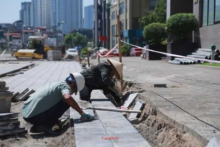 Trên công trường, một số đoạn công nhân tỉ mẩn thi công phần vỉa hè, lát từng viên gạch hoàn thiện không gian đi bộ hai bên đường