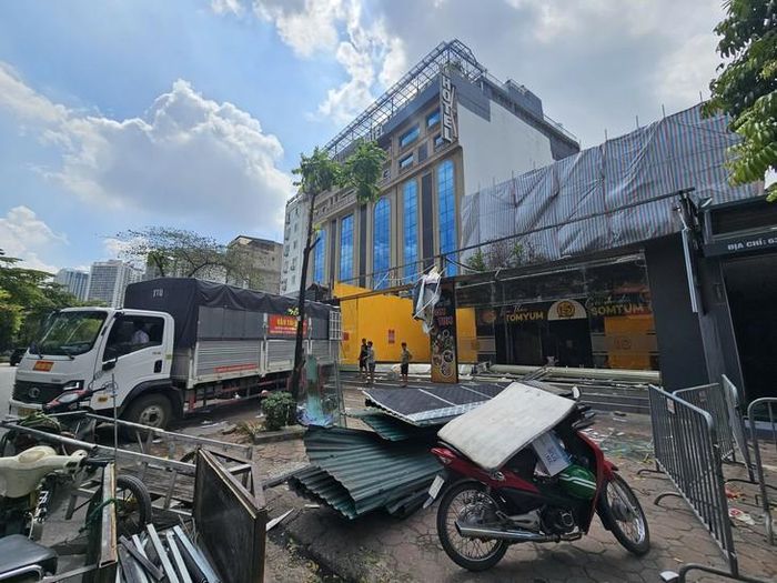 Sau khi tháo dỡ công trình, mái tôn và kết cấu công trình còn sót lại đang được người dân tập trung, thu dọn.