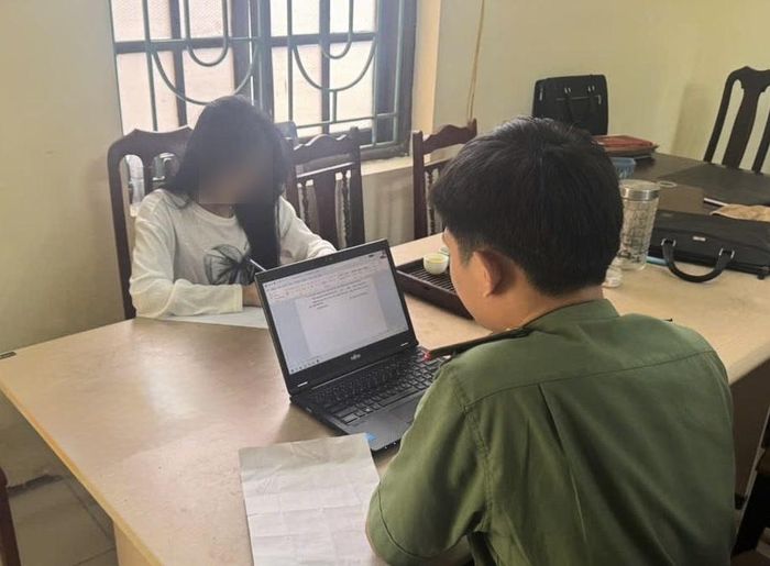 Cán bộ Phòng An ninh mạng làm việc với L.T.C. Ảnh: Cơ quan Công an.