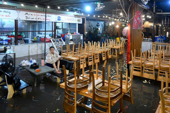  Nước tràn vào một nhà hàng trên đường Nguyễn Văn Khối trong vài giờ. Nhiều nhân viên tại đây cùng nhau kê cao đồ đạc, bàn ghế và ngồi chờ nước rút để về nhà. 