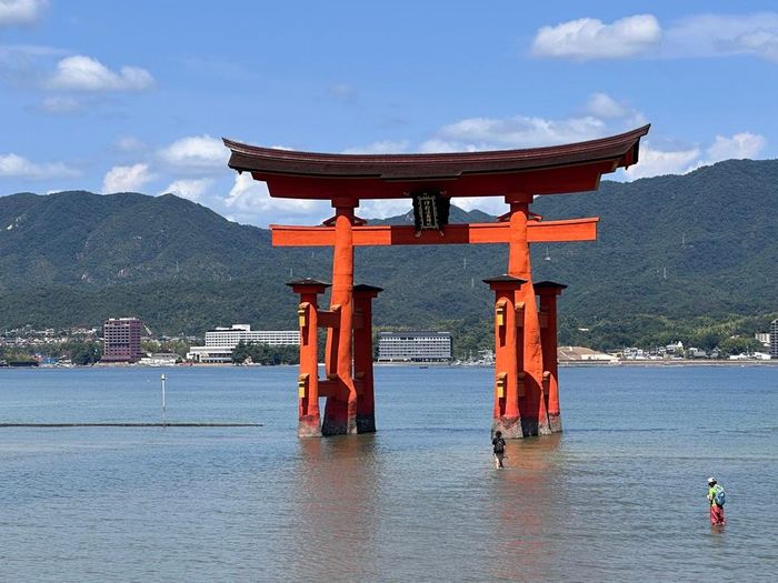 Cổng torii của đền Itsukushima vào thời điểm thủy triều rút, du khách có thể đi bộ trên bãi cát ra tận chân cổng